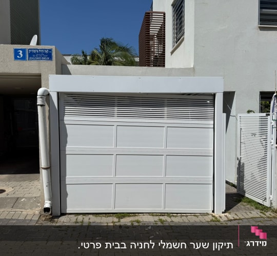 שער חשמלי לבן בכניסה לבית מגורים